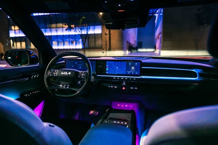 Kia EV9 dashboard and front cabin illuminated at night with blue ambient lighting
